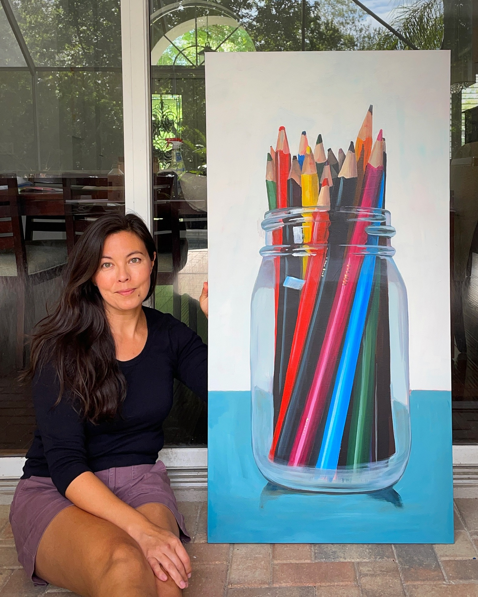 Julia Devon Cohen beside a painting of colored pencils